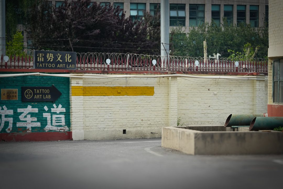 第二步：沿主道直行见绿墙与雷势文化铭牌 · Step 2: green wall with the Lei Shi plate